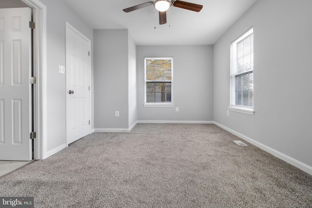 unfurnished bedroom featuring visible vents, carpet flooring, baseboards, and ceiling fan