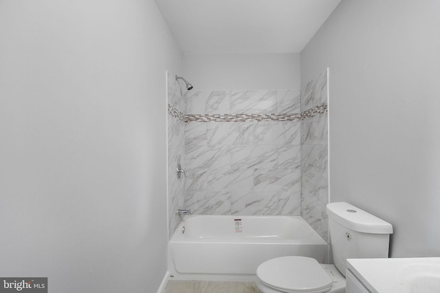 full bathroom featuring tiled shower / bath, vanity, and toilet