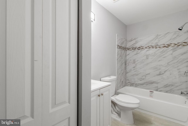 full bathroom with tiled shower / bath, vanity, hardwood / wood-style floors, and toilet