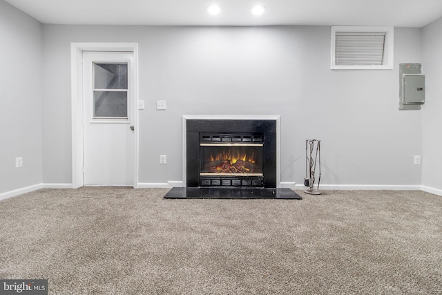 details featuring electric panel, baseboards, a glass covered fireplace, recessed lighting, and carpet floors