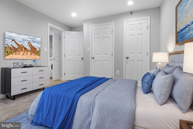 bedroom featuring carpet flooring and multiple closets