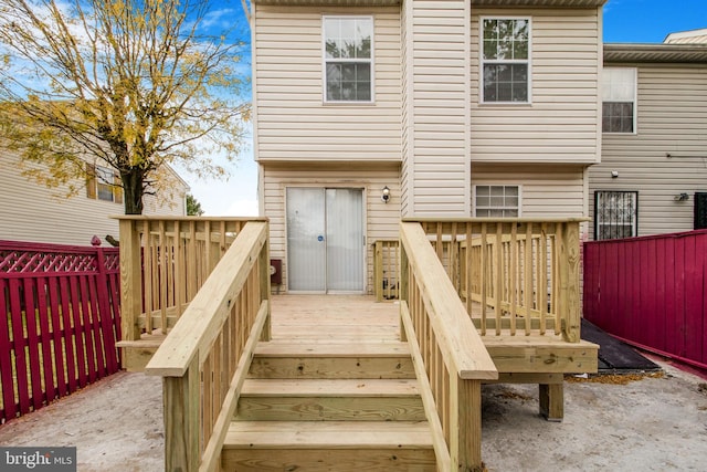 rear view of property with fence, a deck, and stairs