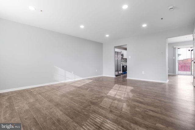 unfurnished living room featuring baseboards, wood finished floors, and recessed lighting