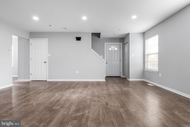 unfurnished living room featuring baseboards, recessed lighting, and dark wood finished floors