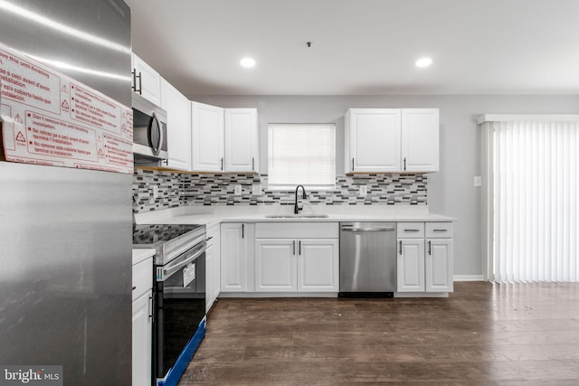 kitchen featuring decorative backsplash, sink, white cabinets, appliances with stainless steel finishes, and dark hardwood / wood-style flooring