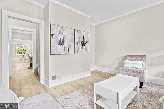 living area with crown molding and wood-type flooring