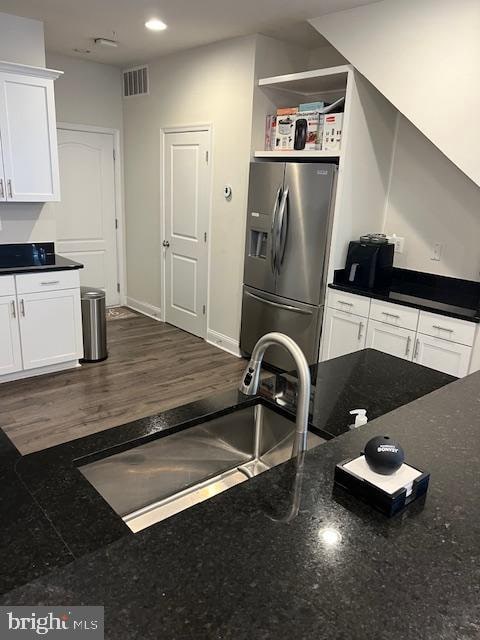 kitchen featuring dark hardwood / wood-style flooring, white cabinetry, sink, and stainless steel fridge with ice dispenser