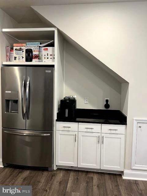 kitchen featuring dark wood-type flooring, stainless steel fridge with ice dispenser, and white cabinets