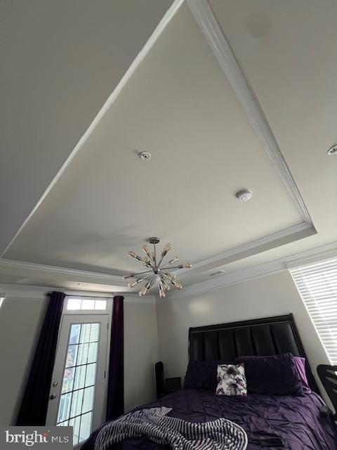 bedroom featuring crown molding, a notable chandelier, and a tray ceiling