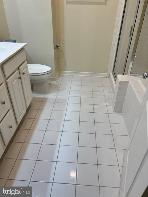 bathroom with vanity, tile patterned floors, toilet, and walk in shower