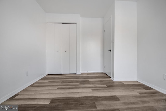 unfurnished bedroom with a closet and light wood-type flooring