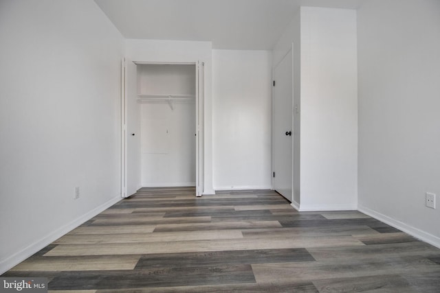 unfurnished bedroom with a closet and dark hardwood / wood-style floors