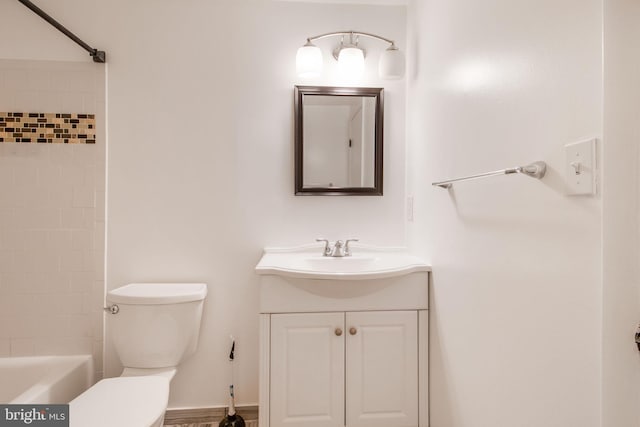 full bathroom featuring toilet, tiled shower / bath, and vanity