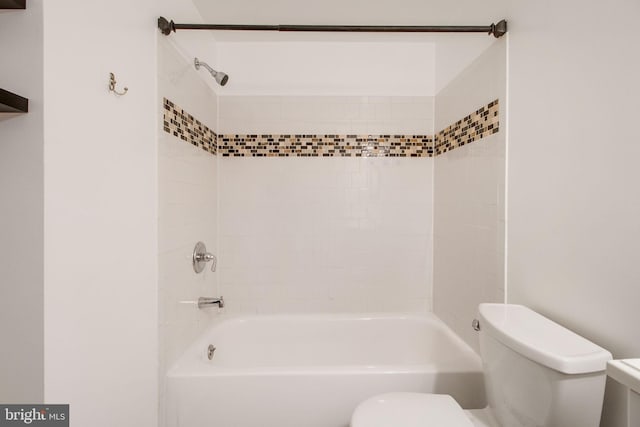 bathroom featuring toilet and tiled shower / bath