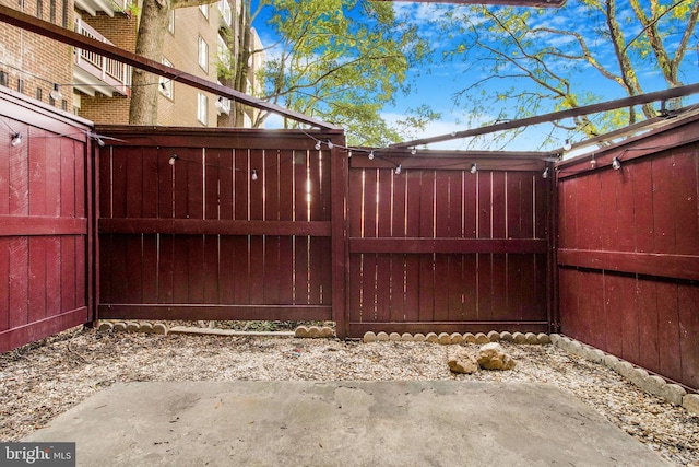 view of gate featuring a patio