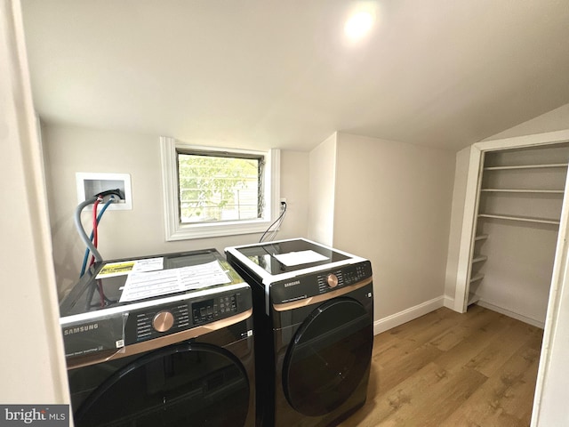 clothes washing area with washer and dryer and light hardwood / wood-style floors