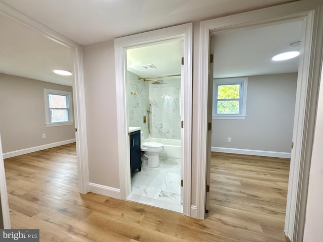 hall with plenty of natural light and light hardwood / wood-style floors