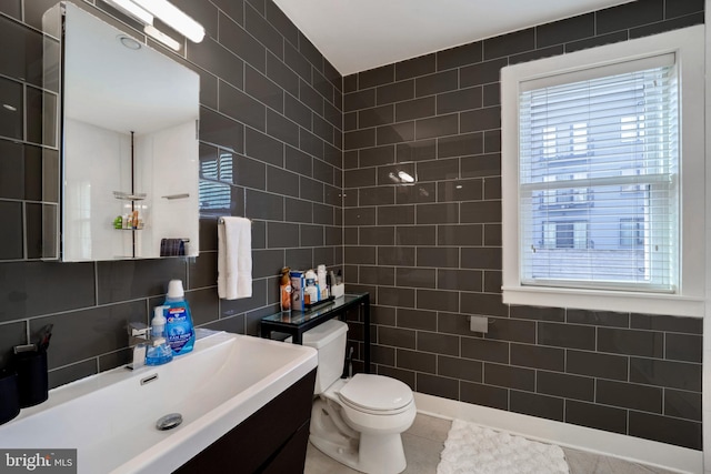 bathroom featuring vanity, toilet, tile patterned floors, and tile walls