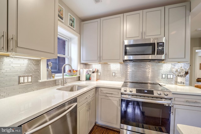 kitchen featuring sink, stainless steel appliances, backsplash, and dark hardwood / wood-style flooring