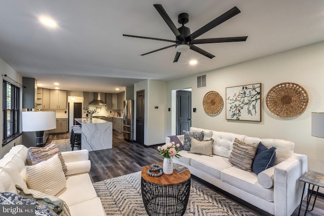 living room featuring dark wood-type flooring and ceiling fan