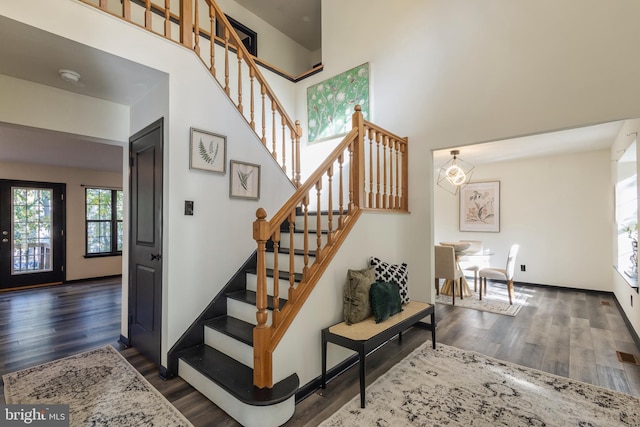 stairway featuring a high ceiling and hardwood / wood-style flooring