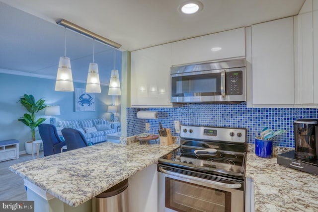 kitchen with white cabinets, crown molding, hanging light fixtures, light hardwood / wood-style floors, and stainless steel appliances