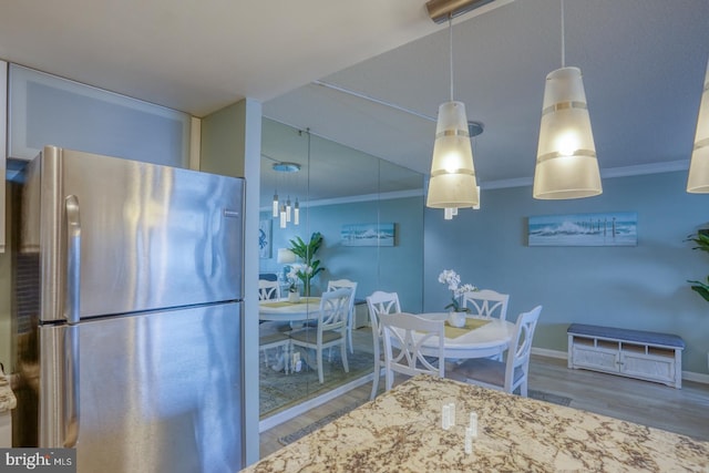 dining space with crown molding and wood-type flooring