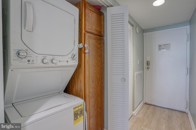 washroom with light wood-type flooring and stacked washer and dryer