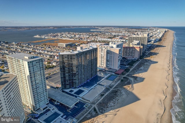 birds eye view of property with a water view and a beach view