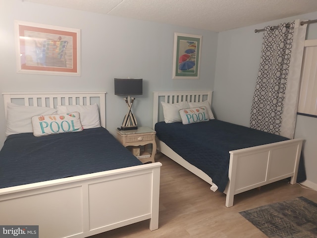 bedroom with wood-type flooring and a textured ceiling