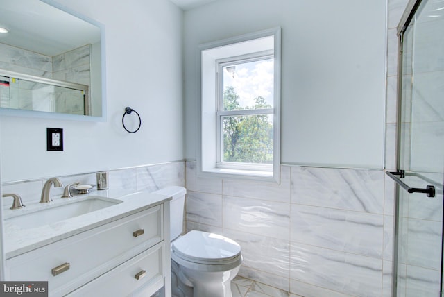 bathroom with tile walls, vanity, toilet, and walk in shower