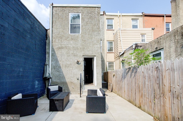 back of property featuring outdoor lounge area and a patio