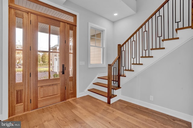 entryway featuring stairway, baseboards, and light wood-style flooring