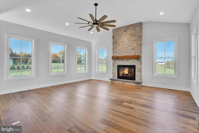 unfurnished living room featuring vaulted ceiling, a fireplace, wood-type flooring, and ceiling fan