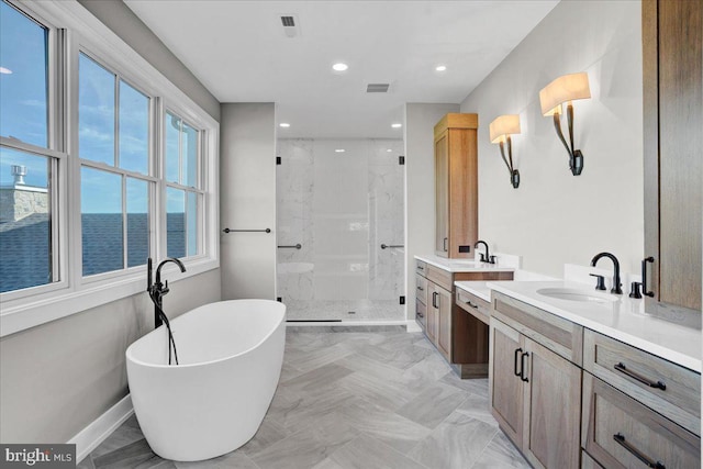 full bath featuring two vanities, a sink, a freestanding bath, baseboards, and a shower stall