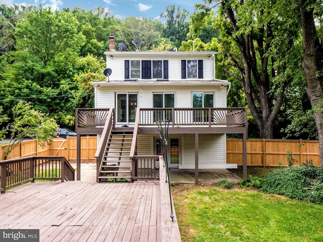 back of house with a wooden deck and a yard