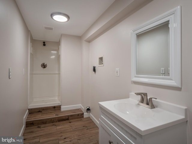 bathroom with vanity, hardwood / wood-style floors, and walk in shower