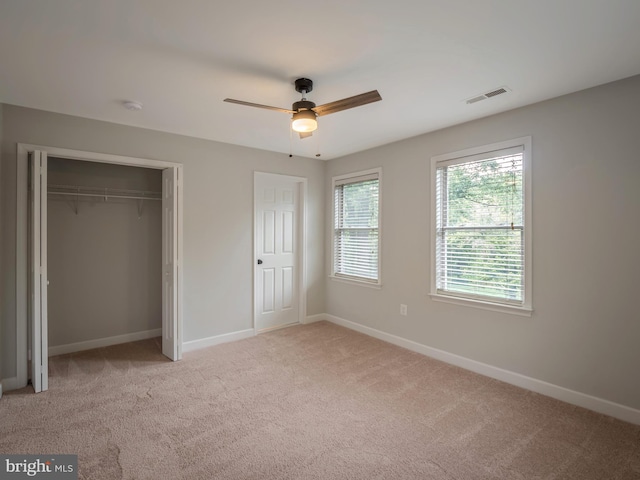 unfurnished bedroom with light carpet, a closet, and ceiling fan