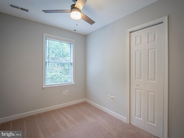 spare room with ceiling fan and carpet