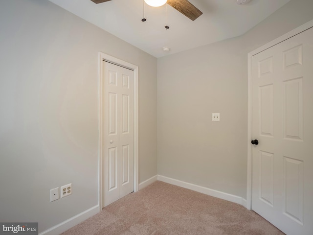 unfurnished bedroom featuring carpet floors, a closet, and ceiling fan