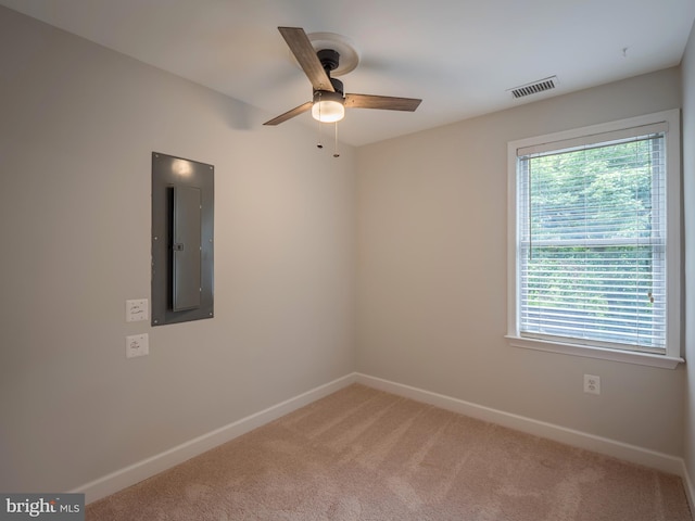 empty room with ceiling fan, electric panel, and carpet