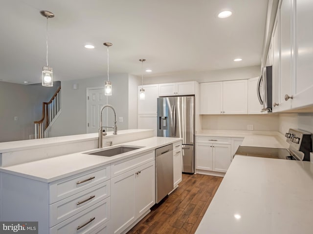 kitchen featuring sink, hanging light fixtures, appliances with stainless steel finishes, dark hardwood / wood-style flooring, and white cabinets