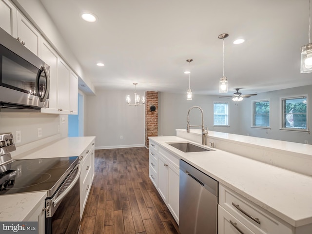 kitchen featuring sink, decorative light fixtures, dark hardwood / wood-style floors, stainless steel appliances, and white cabinets