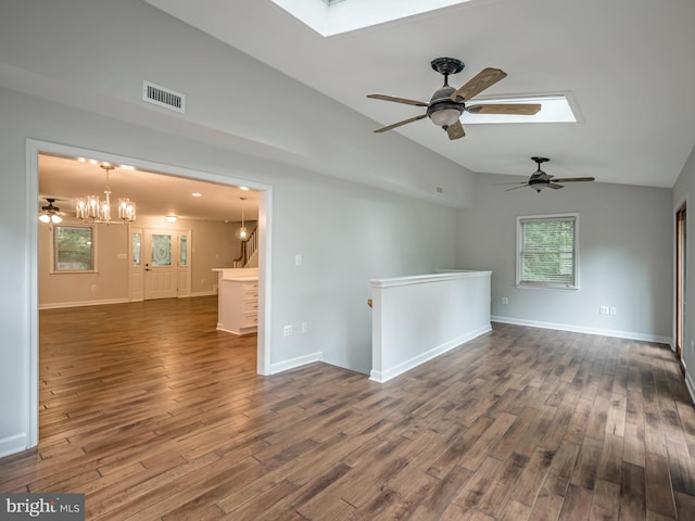 empty room featuring lofted ceiling with skylight, dark hardwood / wood-style floors, and a notable chandelier