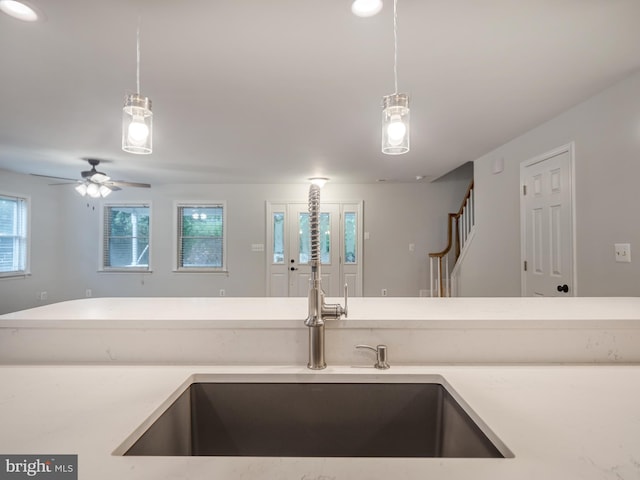 kitchen featuring ceiling fan, sink, and hanging light fixtures