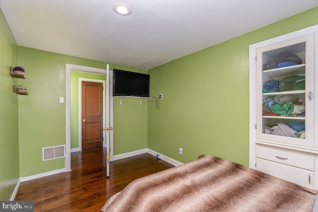 bedroom with dark hardwood / wood-style floors