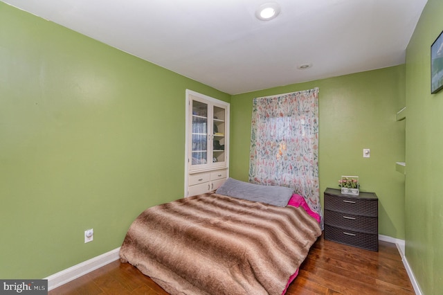 bedroom with dark hardwood / wood-style flooring