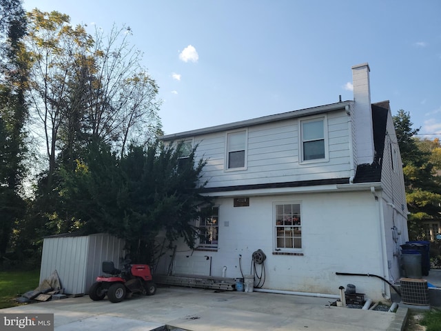 back of property with a patio and a storage unit