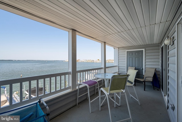 sunroom featuring a water view