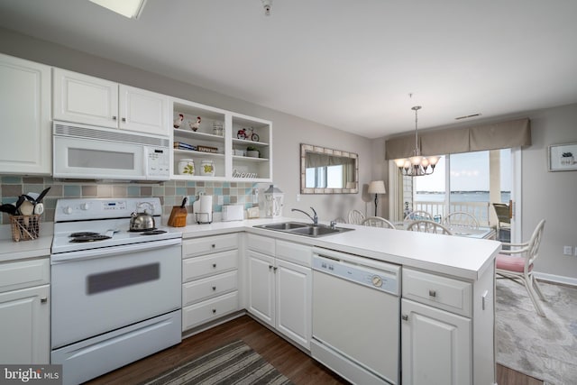 kitchen with kitchen peninsula, white cabinets, and white appliances